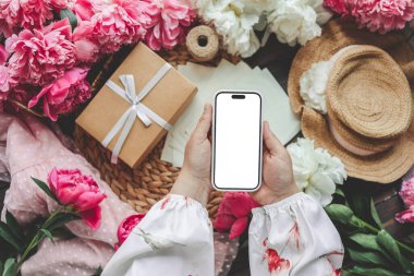 Neşeli bir arka planda cep telefonu ve bahar çiçekli şakayıklar. Aşk teması, Anneler Günü, Kadınlar Günü düzlük.