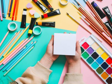Okula dönelim. Panoramik eğitim afişi. Üst manzara, düz yatış. Masada renkli malzemeler, renkli kağıtlar. Çocukların yaratıcılık kavramı. Anaokulu eğitimi, gelişme. Okul için aksesuarlar..