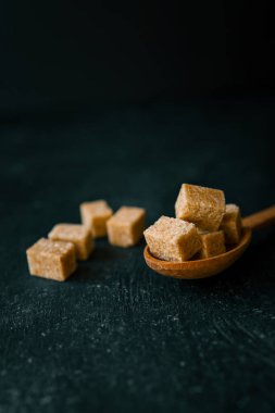 bruine suiker heap en houten lepel.