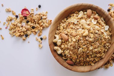 Beyaz zemin üzerinde fındık ve badem olan tahıl, etrafa dağılmış tahıl.