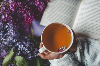 Bir fincan bitki çayı ve bir buket leylak..