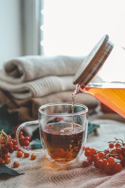 Sonbahar kompozisyonunda Viburnum ile bir fincan çay..