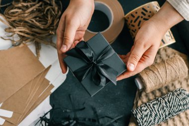 Paketleme malzemeleri ve hediyeler için arkaplanda fiyonklu bir hediye kutusu..