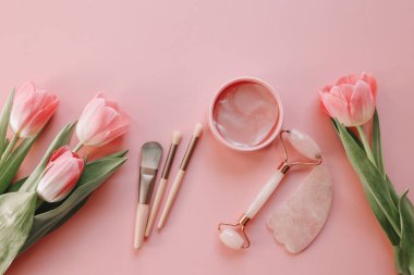 Üst görünüm kozmetik seti, makyaj fırçaları, göz bantları, yüz silindiri.