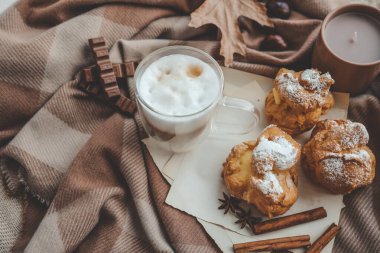 Sıcak sabah kompozisyonu, bir fincan kahve, kremalı pasta ve mum..