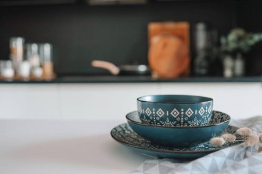 Mutfağın arka planına karşı masasında süs olan şık tabaklardan oluşan bir set..