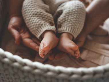 Annenin ellerinde yeni doğmuş bir bebeğin küçük bacakları annelik ve bakım kavramı..