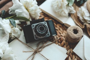 Kitap ve taze pembe şakayık çiçekli retro fotoğraf makinesi.