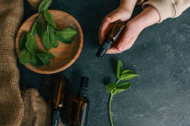 Elinde nane, sağlık ve ilaç bulunan doğal kozmetik ürünleri..