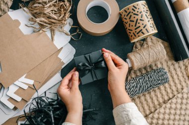 Paketleme malzemeleri ve hediyeler için arkaplanda fiyonklu bir hediye kutusu..