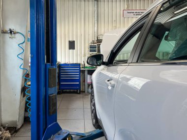 Benzin istasyonunda asansördeki beyaz araba..