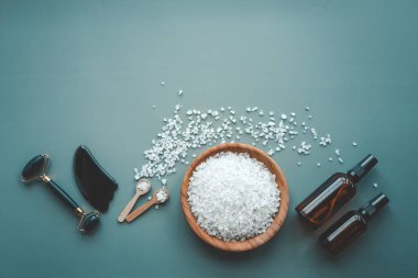 Yüz ve vücut bakımı için kozmetik ürünler seti, düz üst görünüm yatıyordu. Banyo tuzu, yağ kavanozu ve gua sha kazıyıcı.