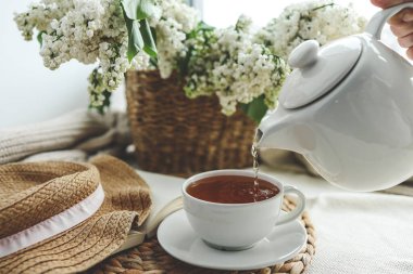 Çaydanlıktan bir fincana çay dökülüyor, güzel estetik bir fotoğraf..