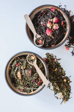 Beyaz arka planda bitki ve çiçek çayı ile tabaklar.