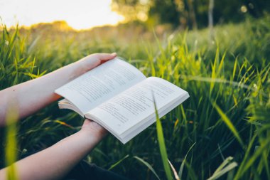 Elinde açık bir kitap, doğa konsepti, sükunet ve yalnızlık..