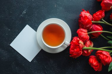 Mesajın, çayın ve bahar çiçeklerinin olduğu tebrik kartı..