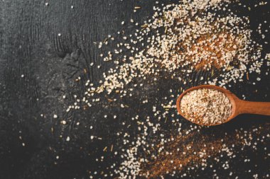 Tahta kaşık, deniz tuzu ve baharatlı siyah arka plan..