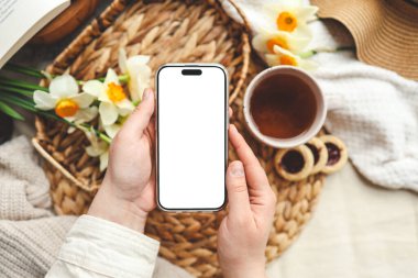 Yay bileşiminin arka planında izole ekran ile telefon ile eller.
