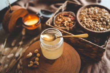 Jar with natural honey on granola background, good morning concept.