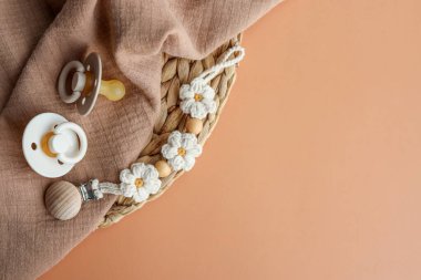 Bebek eşyaları, yeni doğanlar için moda. Emzikler, tutucu, ekose üst görünüm, düz uzanma, metin için boşluk.