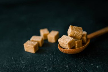 bruine suiker heap en houten lepel.