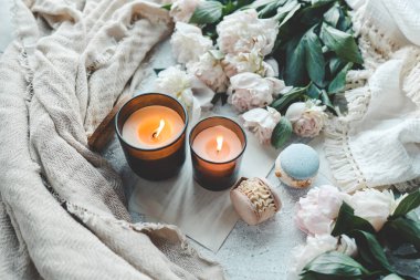 Sıcak bir evde yanan iki mum, beyaz şakayıklar ve badem kurabiyeleri..