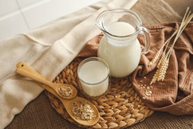 Süt sürahisi ve bir kase süzme peynir ahşap mutfak masasında..