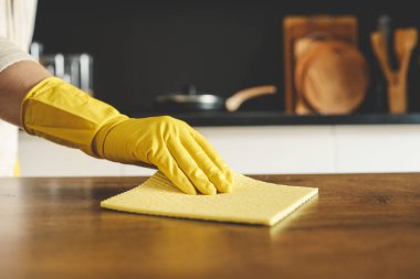 Portre sarı koruyucu lastik eldiven mutfak dolapları sünger ile temizlik kadının ellerinde.