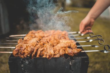 Adam gün içinde arka bahçede ızgara ızgara domuz eti yapıyor. Aile yemeği açık hava tarzı bbq etkinliği.