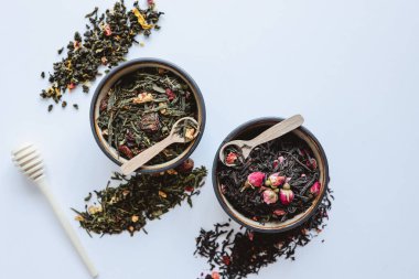 Beyaz arka planda bitki ve çiçek çayı ile tabaklar.