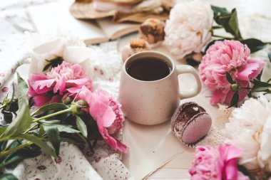 Bir fincan çay, badem kurabiyesi ve şakayık, düz bir manzara. Günaydın konsept.