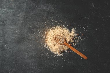 Tahta kaşık, deniz tuzu ve baharatlı siyah arka plan..