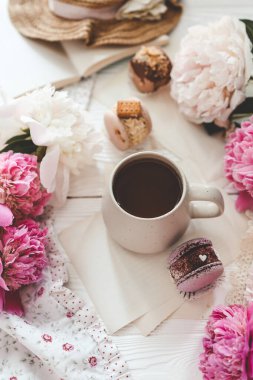 Bir fincan çay, badem kurabiyesi ve şakayık, düz bir manzara. Günaydın konsept.