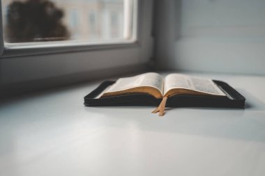 Pencerenin kenarında İncil, şehir manzarası, sabah namazı.