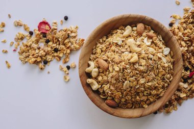 Beyaz zemin üzerinde fındık ve badem olan tahıl, etrafa dağılmış tahıl.