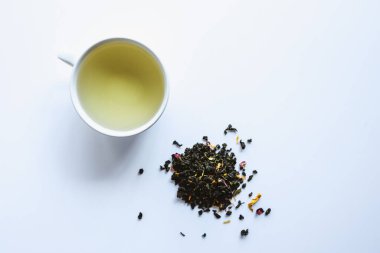 Beyaz arka planda bir fincan bitki çayından yapılmış yaratıcı bir düzen. Üst görünüm.