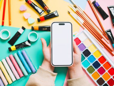 Bir okul çocuk ofisinin arka planında izole bir ekran bulunan telefon ellerinde..