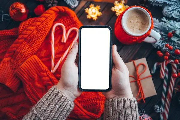 Noel atmosferinde metin için izole edilmiş bir yere sahip telefon ellerinde.