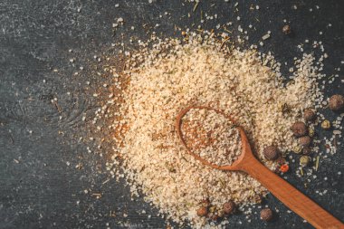 Tahta kaşık, deniz tuzu ve baharatlı siyah arka plan..