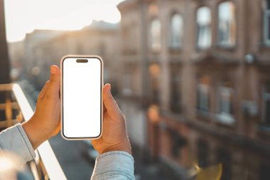 Antik binaların arka planında izole bir ekran bulunan telefon ellerinde.