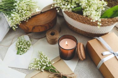 Kutlama konsepti, vadideki zambak, hediye kutusu, yanan mum ve mektup..