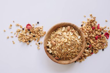 Beyaz zemin üzerinde fındık ve badem olan tahıl, etrafa dağılmış tahıl.