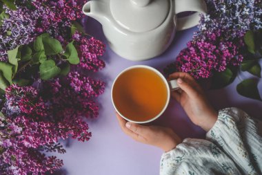 Bir fincan bitki çayı ve bir buket leylak..