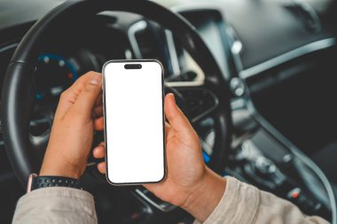 Arabadaki bir kadının ellerinde izole bir ekran olan bir telefon..