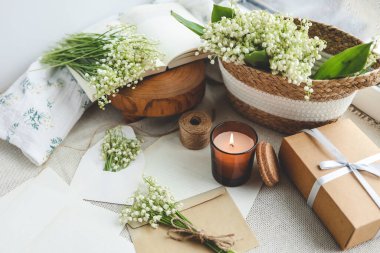 Kutlama konsepti, vadideki zambak, hediye kutusu, yanan mum ve mektup..