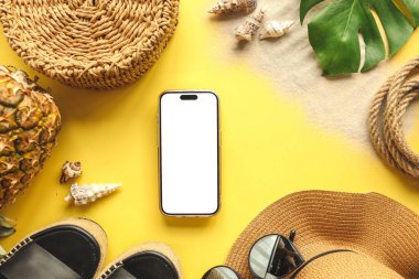 Yaz aksesuarlarının arka planında izole bir ekran olan telefon, reklam için bir yer.