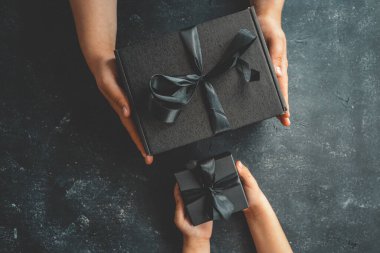 Elinde fiyonk olan hediye kutuları, Kara Cuma konsepti..