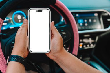 Arabadaki bir kadının ellerinde izole bir ekran olan bir telefon..
