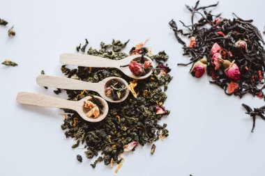 Beyaz arka plan görünümlü bitkisel çay ve tahta kaşıklar..