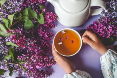 Bir fincan bitki çayı ve bir buket leylak..